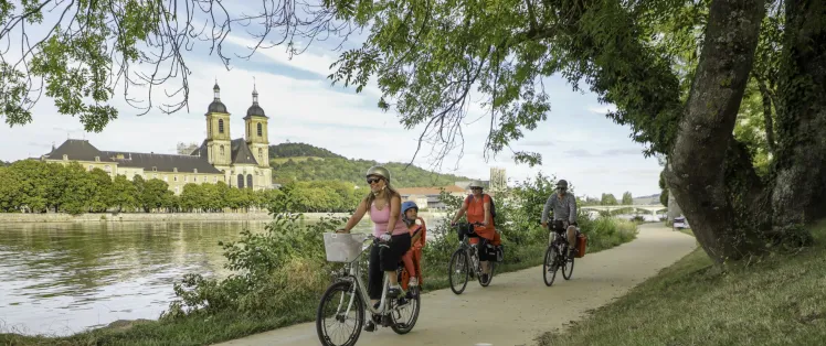 Famille à vélo sur le halage de la Moselle à Pont-à-Mousson devant l'abbaye des Prémontrés